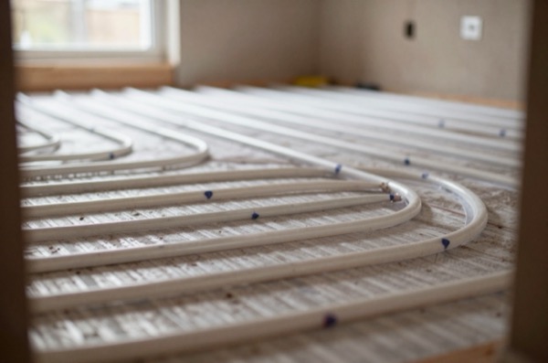 Construction site showing underfloor heating pipes under screed.