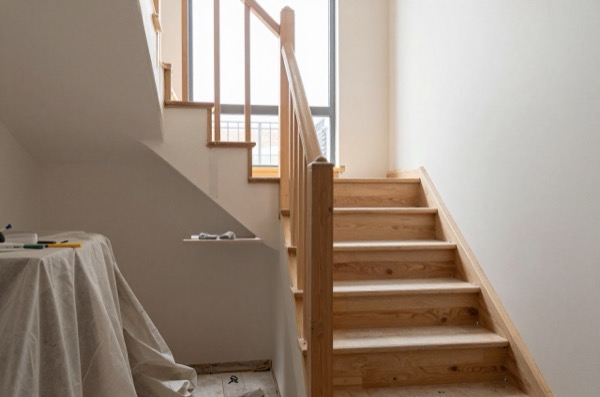 Staircase under renovation with exposed treads and natural light.