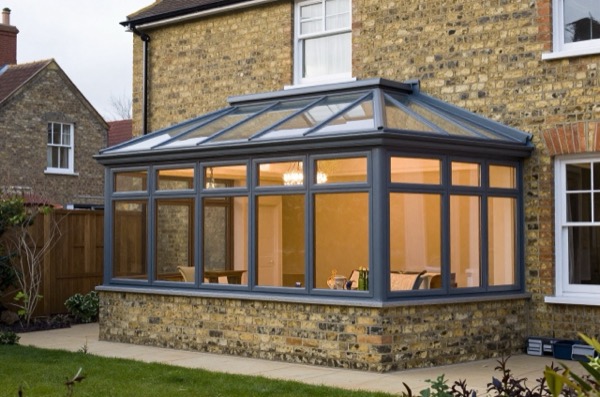 Comparison of a modern conservatory and classic orangery attached to a British home.