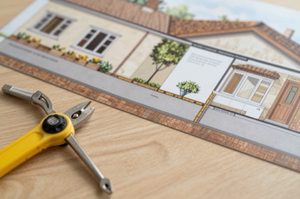 Architectural illustration of a property boundary with a party wall and surveyor tools.