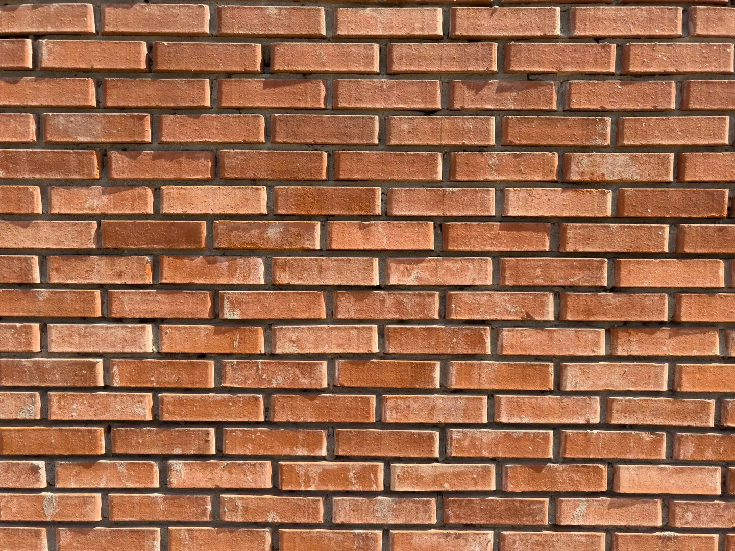 High-resolution image of a red brick wall texture with detailed rustic patterns.