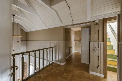 Cozy hallway with wooden interior and a staircase leading to upper floor.