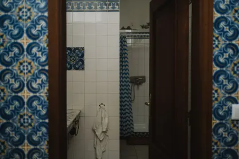 Bathroom with vintage blue tile design and shower, offering a classic feel.
