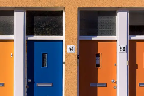 Brightly coloured doors with numbers 54 and 56 on a modern building facade.