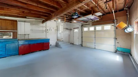 Empty garage with open space and colourful storage cabinets.