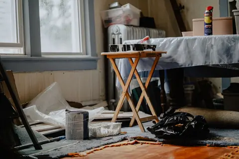 Interior view of a home renovation with paint supplies on a wooden table.