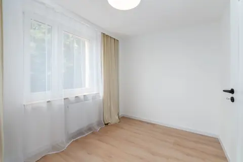 Bright and empty room with sheer curtains and wooden floor, perfect for interior design ideas.