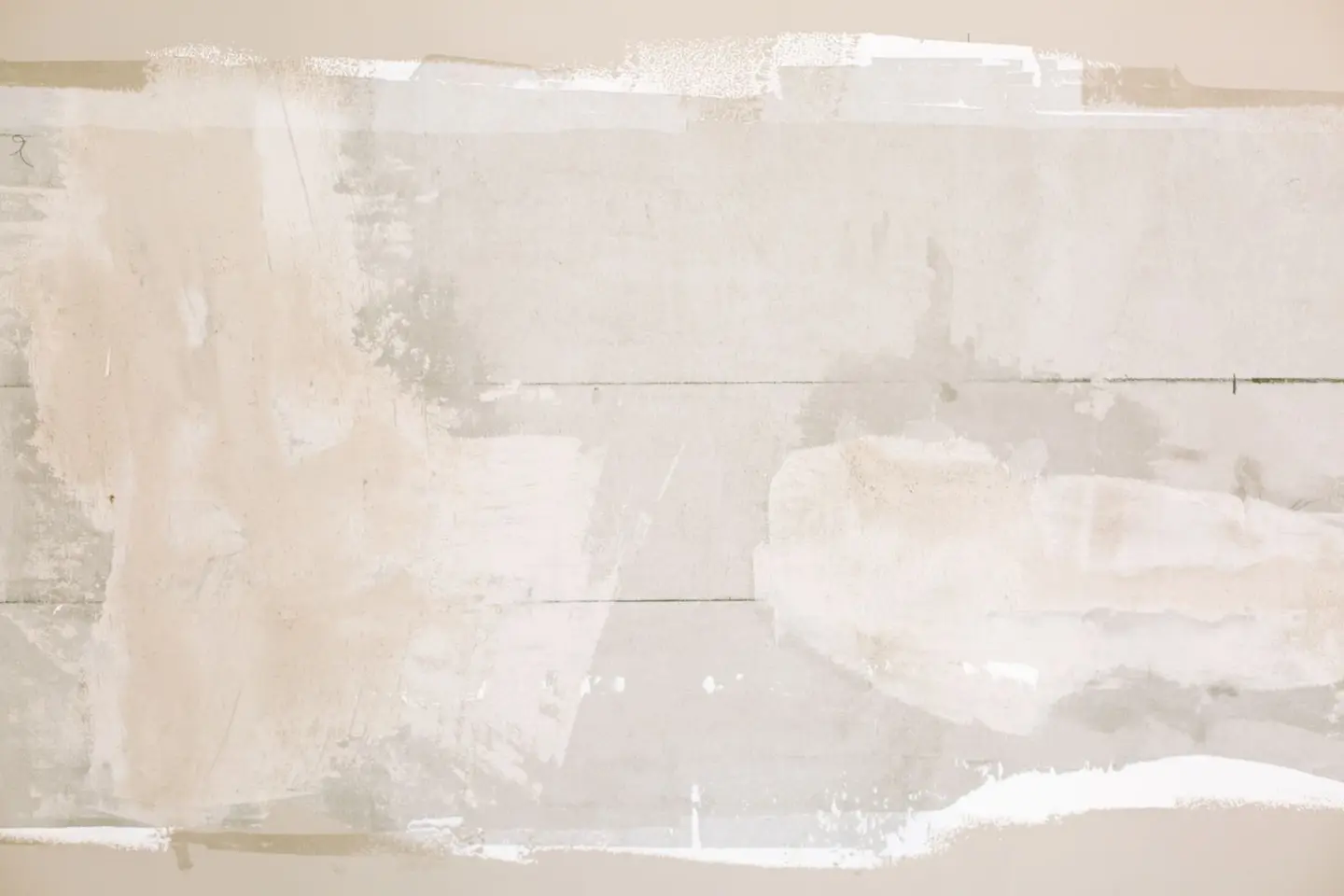 Close-up of an unfinished wall showing plaster and paint textures in a home renovation.