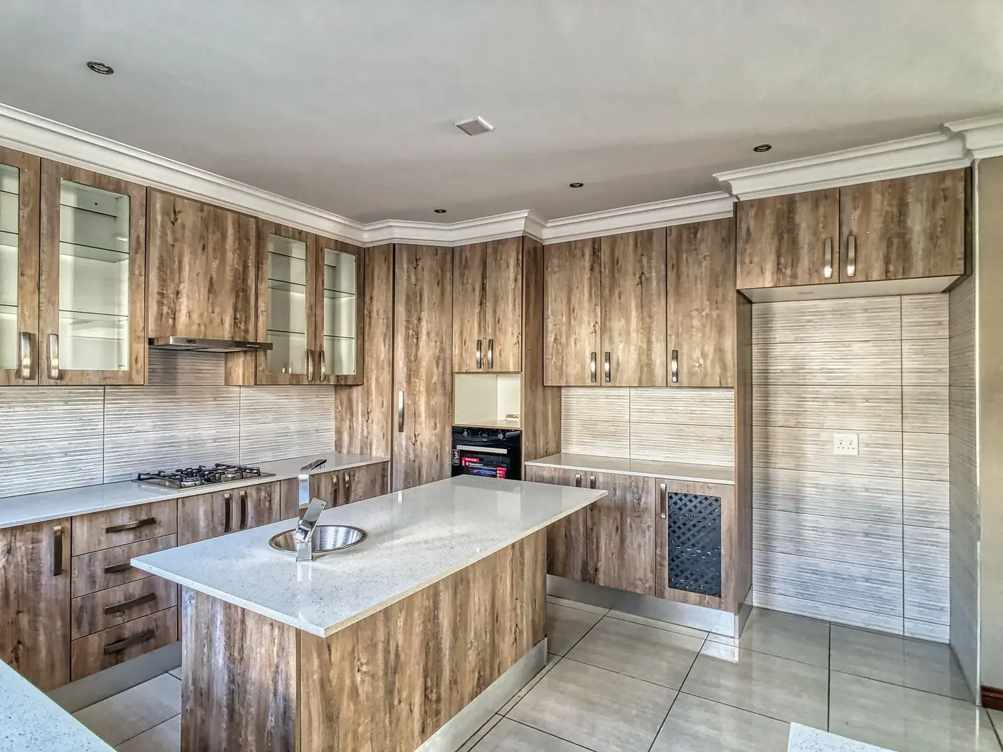 Spacious modern kitchen with wooden cabinets and island in elegant interior setting.