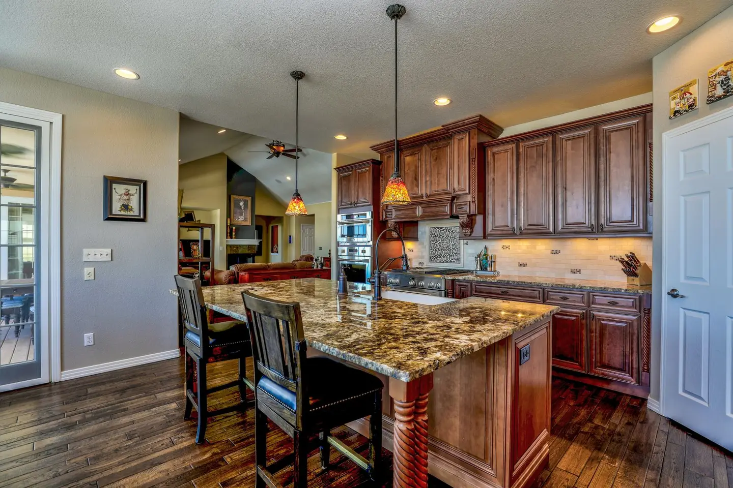 A stylish kitchen featuring a granite island, wooden cabinets, and modern appliances. Perfect blend of rustic and contem