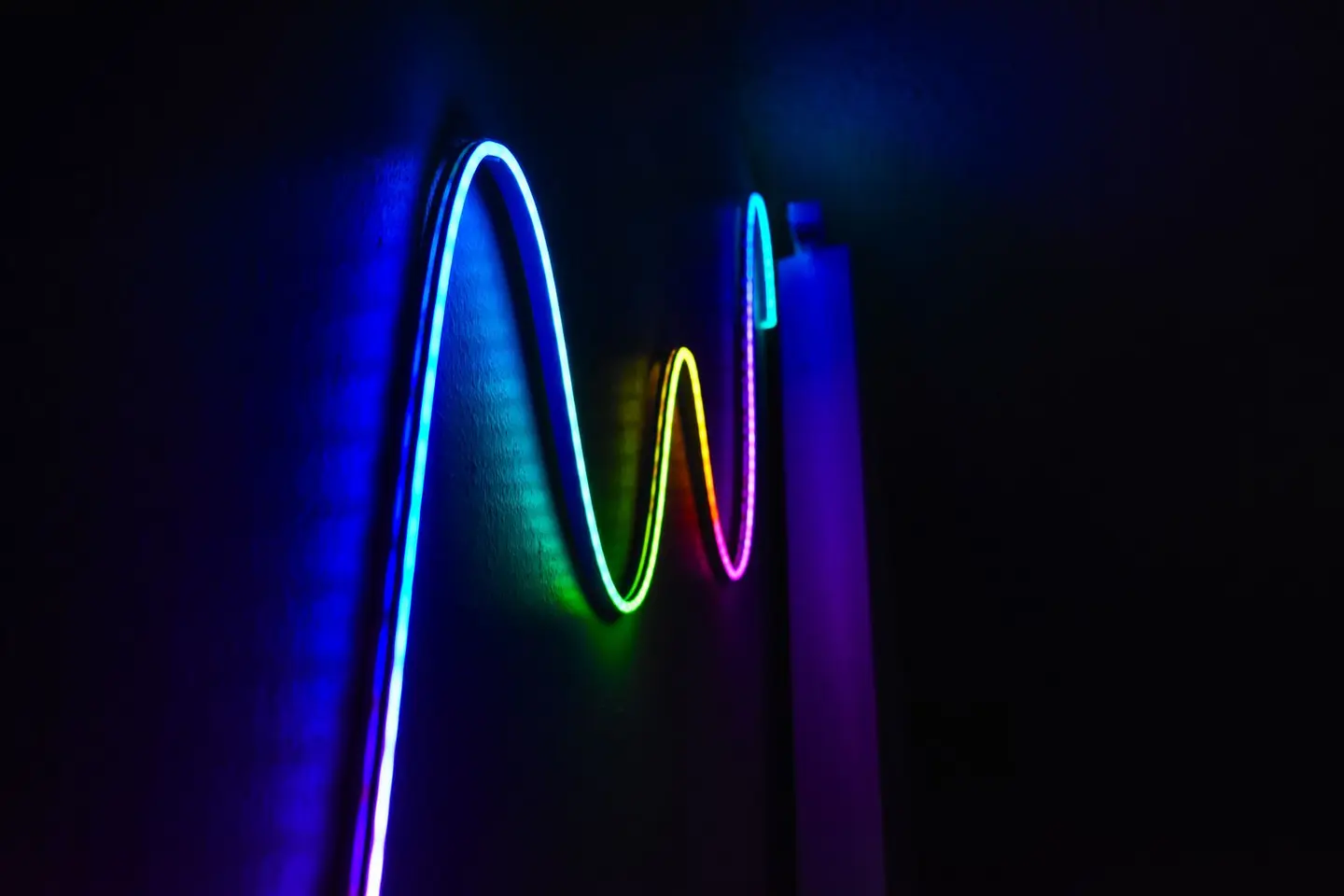 colourful neon wave pattern LED lights illuminating a dark room for a modern home decor aesthetic.