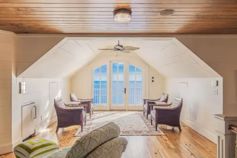 Bright and luxurious loft overlooking the ocean, featuring modern furniture and design.