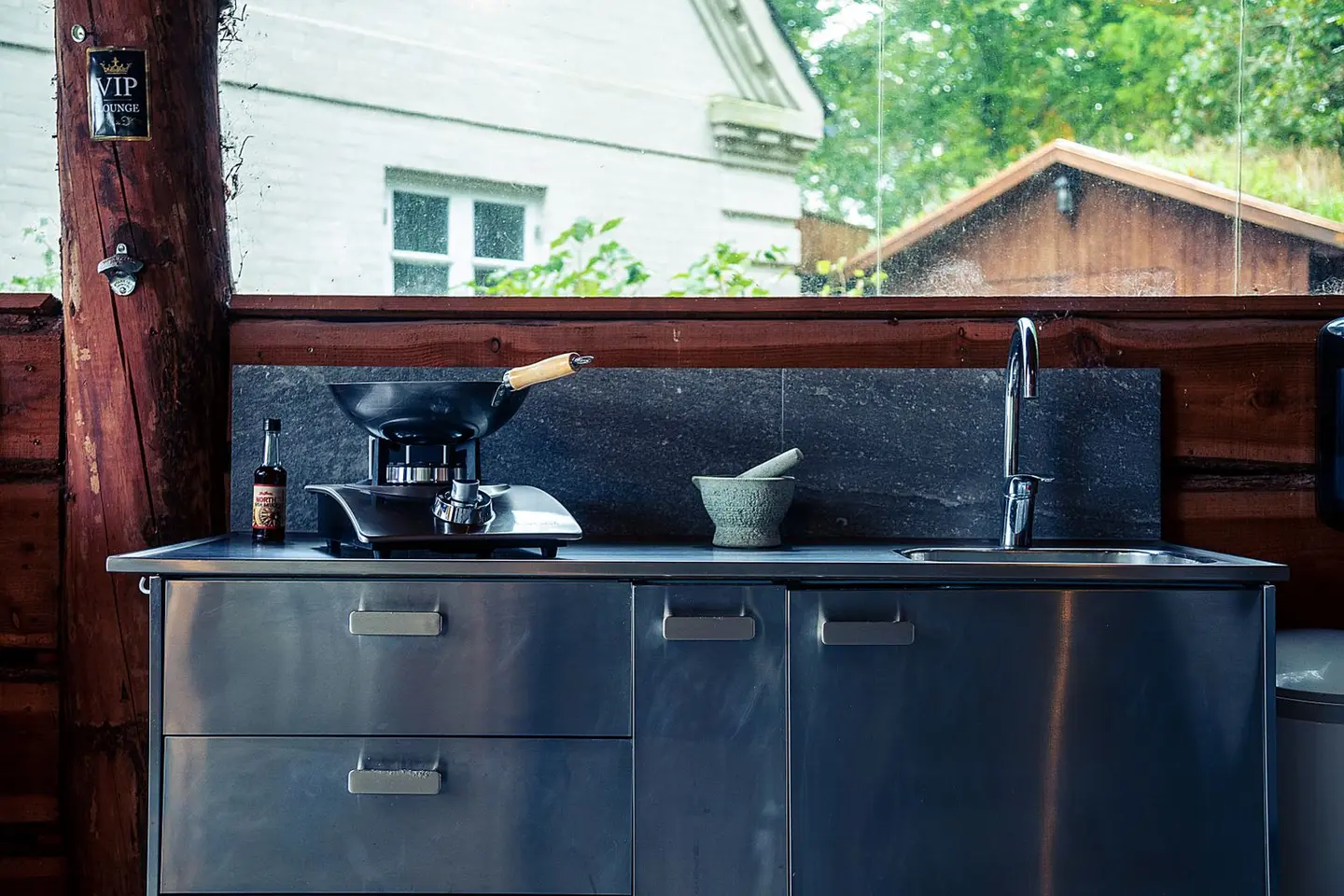 Stylish outdoor kitchen setup with a wok and sink, perfect for outdoor cooking enthusiasts.