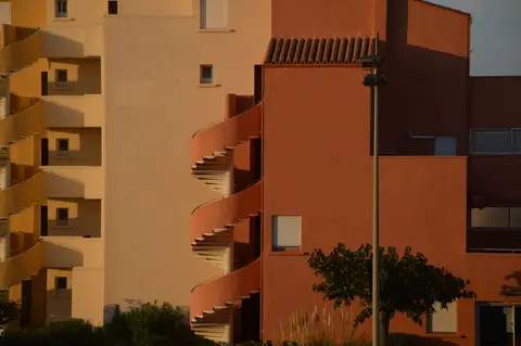 Modern residential building with a distinct spiral staircase and colourful facades.