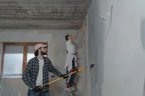A couple painting a room together, highlighting teamwork in home renovation.