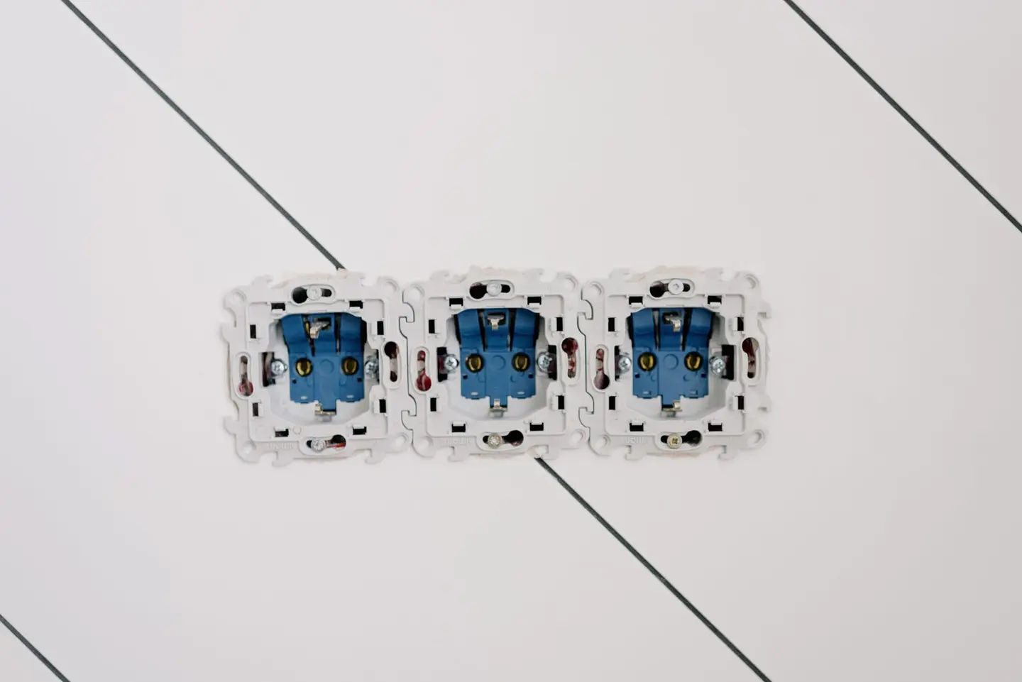Power sockets with various connectors and bolts on wall in room at home